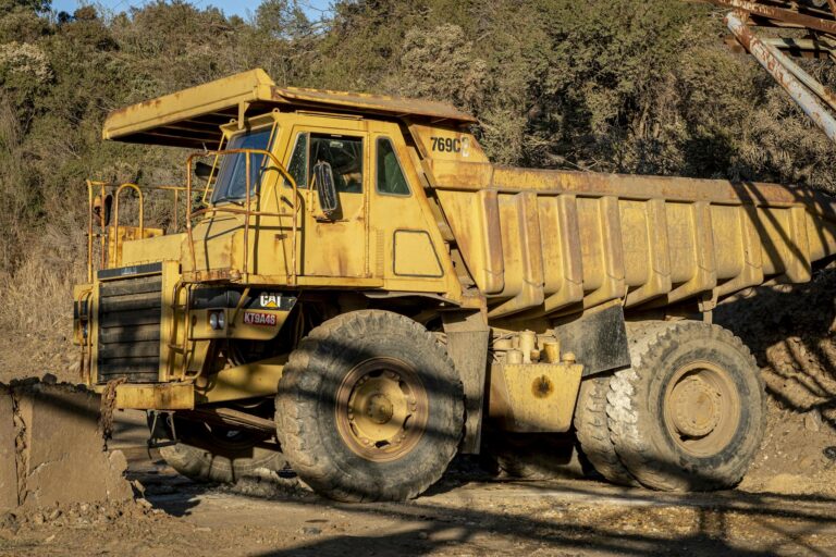 A heavy-duty dump truck on a construction site during daytime, showcasing industrial machinery in action.