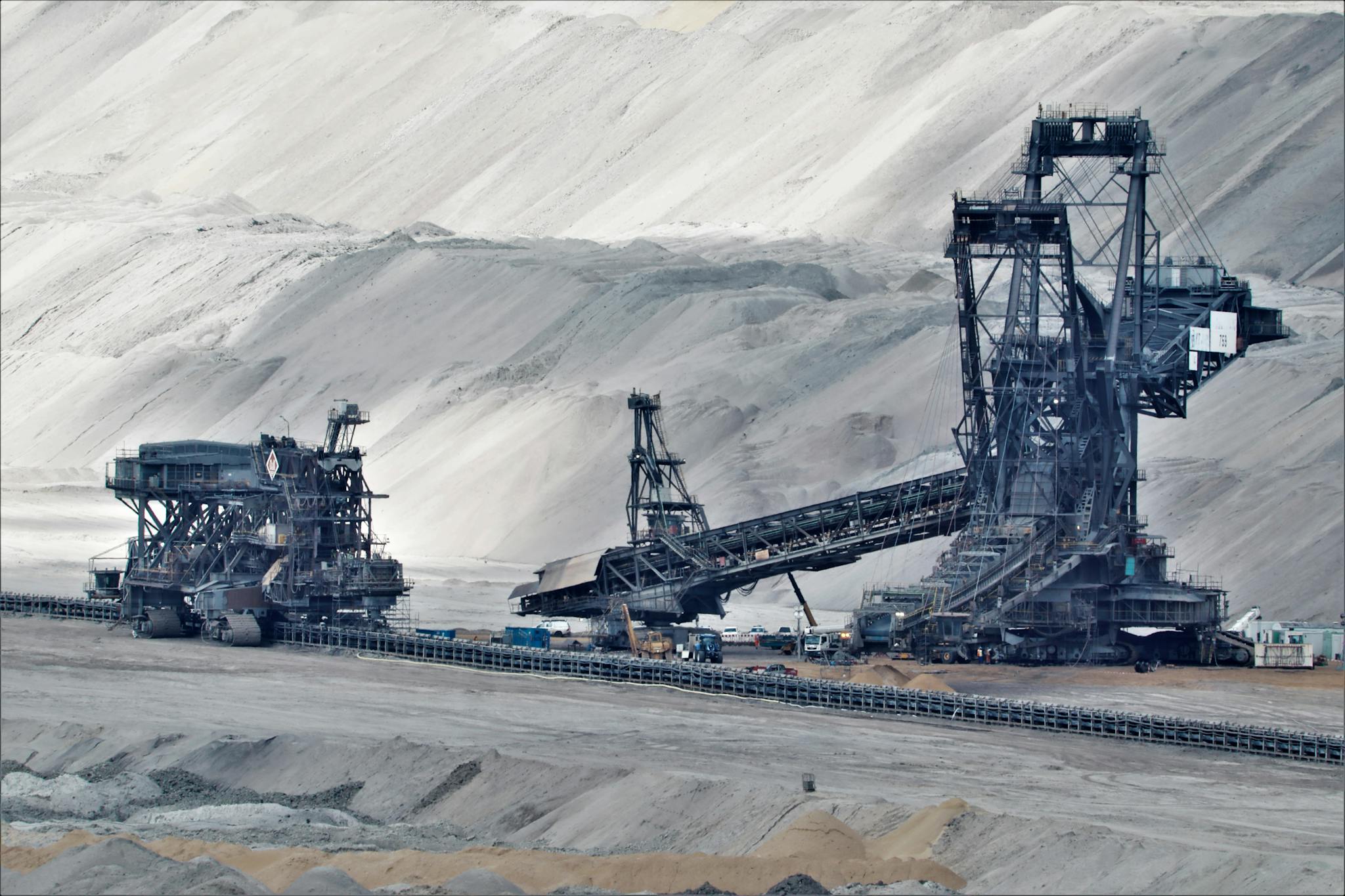 About A large bucket wheel excavator operates in a vast industrial mining area, illustrating heavy machinery in action.